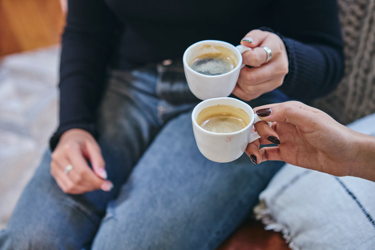 Dos personas comparten un café en tazas blancas